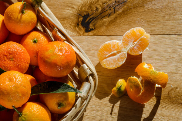 Clementine in cesto, su sfondo legno
