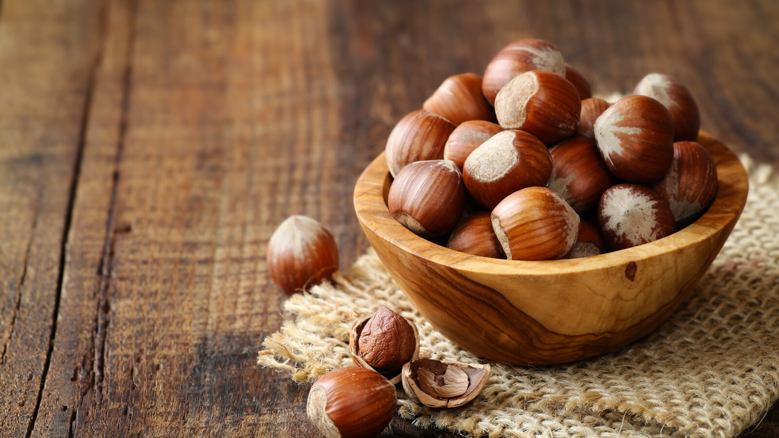 Hazelnuts in a wooden bowl on rustic background