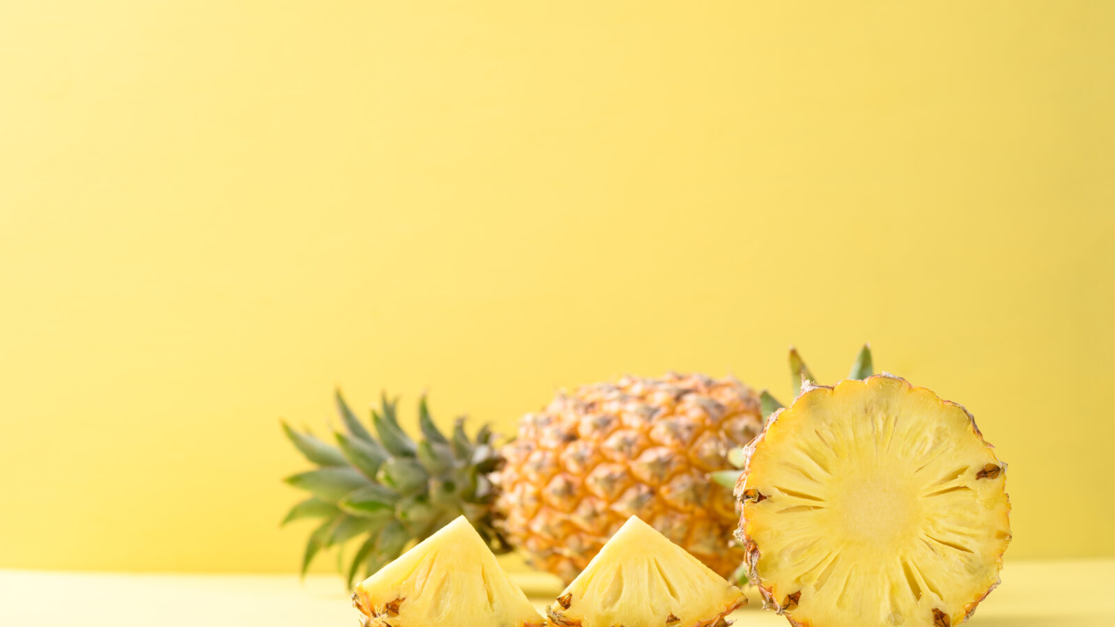 Sliced pineapple fruit on yellow background, Tropical fruit